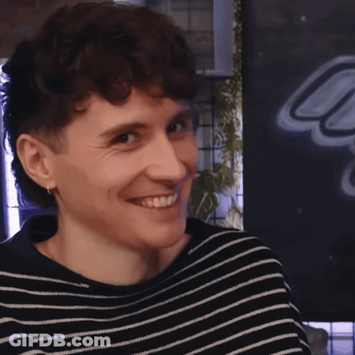 Young Man In Black And White Striped Sweater Smiling GIF