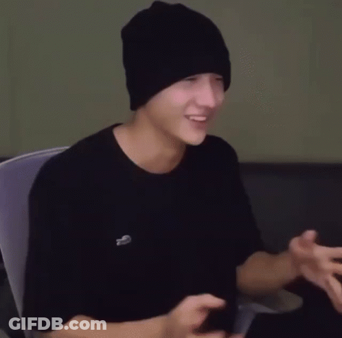 Young Man In Black Beanie And T-Shirt Sitting GIF