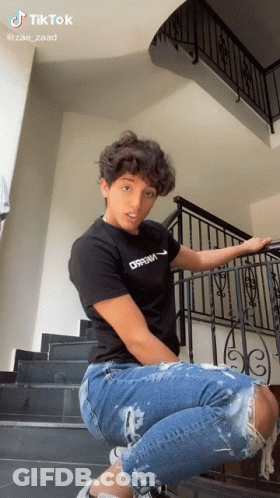 Young Man In Black Dream Shirt On Stairs GIF