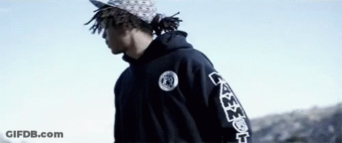 Young Man In Black Hoodie And Hat Against Blue Sky GIF