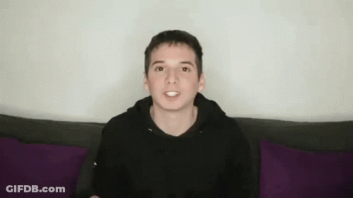Young Man In Black Hoodie With Funny Face On Purple Couch GIF
