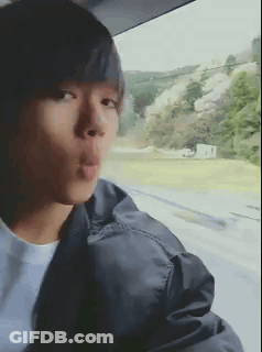 Young Man In Black Jacket Blowing Kiss Out Car Window GIF