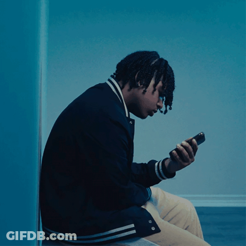 Young Man In Black Jacket Looking At Phone GIF