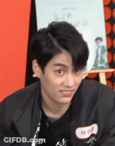 Young Man In Black Jacket Making Funny Face At Easel GIF
