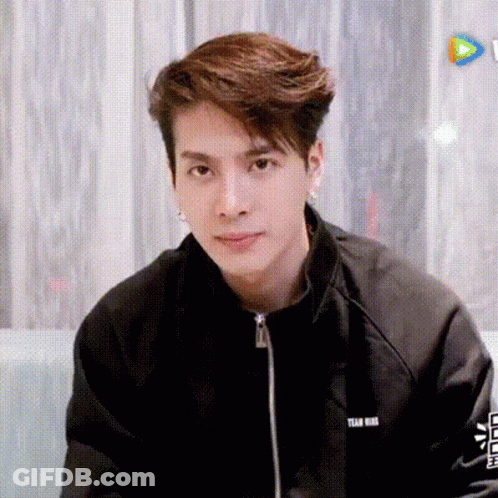 Young Man In Black Jacket Sitting On Couch GIF