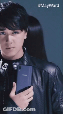Young Man In Black Leather Jacket Holding Vivo Phone GIF