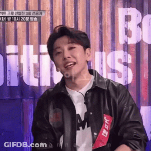 Young Man In Black Leather Jacket Smiling At Be Sign GIF