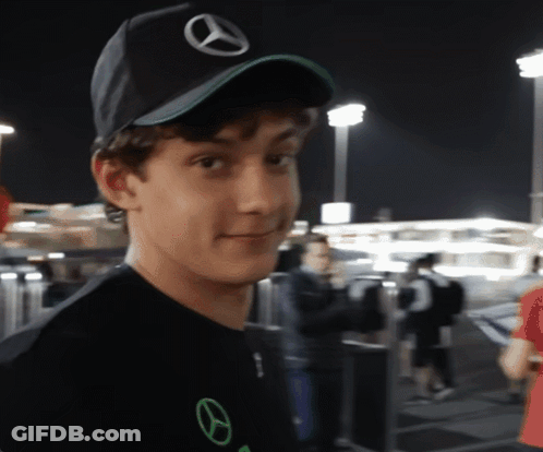 Young Man In Black Mercedes Hat Looking At Camera GIF