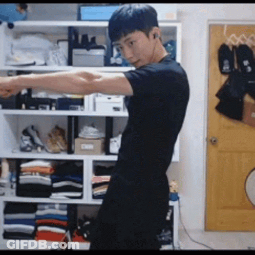 Young Man In Black Shirt By Closet Full Of Clothes GIF