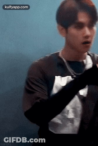 Young Man In Black Shirt Looking At Camera GIF