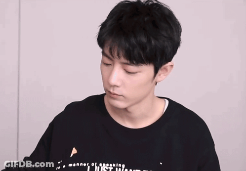 Young Man In Black Shirt With Chinese Writing Making A Face GIF