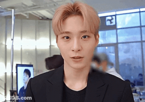 Young Man In Black Suit Standing In Front Of Window GIF
