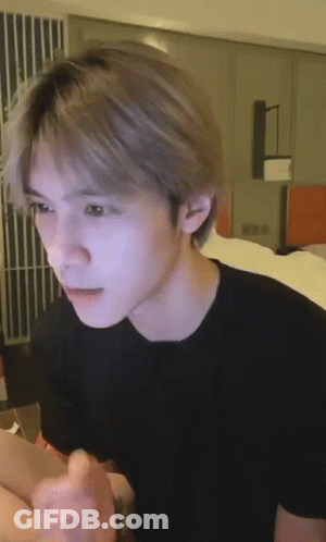 Young Man In Black T-Shirt Sitting On Bed GIF