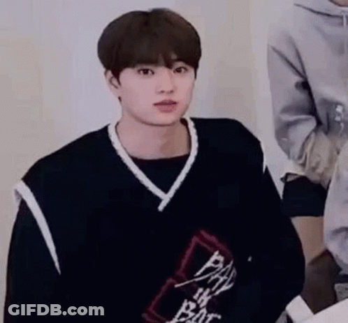 Young Man In Black Vest And Sweater Sitting GIF
