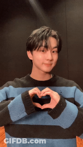 Young Man In Blue And Black Striped Sweater Making Heart Shape GIF