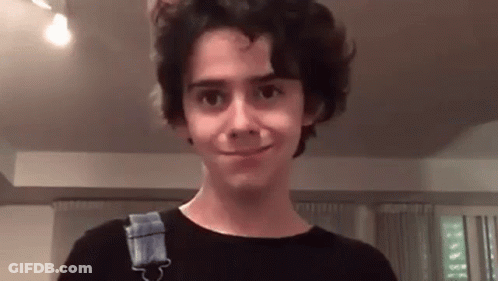 Young Man In Blue Geek Shirt In Front Of Stop Sign GIF