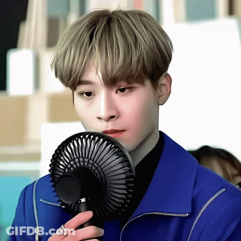 Young Man In Blue Jacket Holding Fan GIF