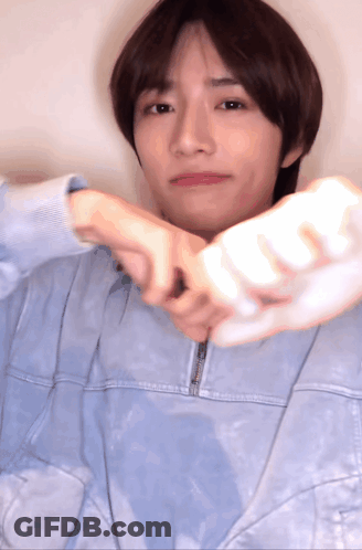 Young Man In Blue Jacket Holding White Object GIF