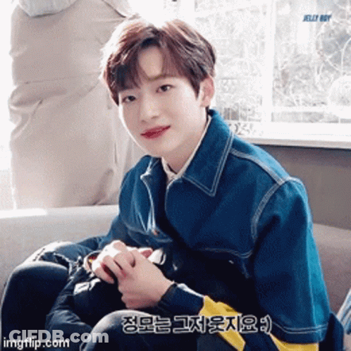 Young Man In Blue Jacket Sitting By Window GIF