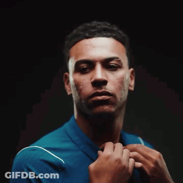 Young Man In Blue Shirt Adjusting Tie GIF
