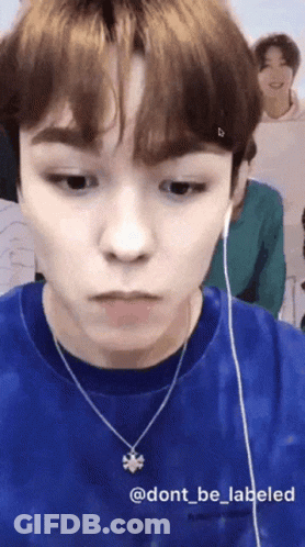 Young Man In Blue Shirt And Bee Necklace GIF