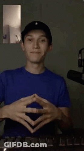 Young Man In Blue Shirt And Black Hat Making Funny Face GIF
