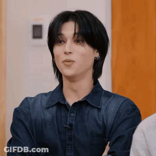 Young Man In Blue Shirt And Earrings Staring GIF