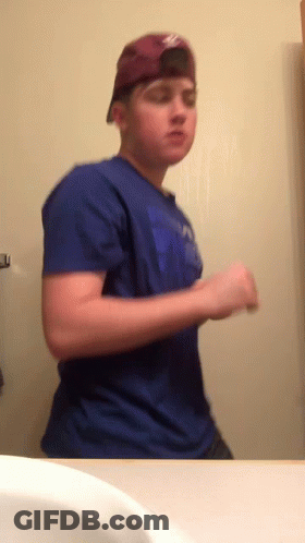 Young Man In Blue Shirt And Hat At Mirror GIF