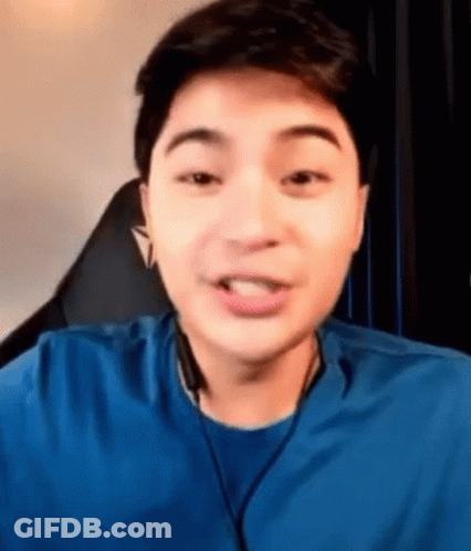 Young Man In Blue Shirt And Headphones Sitting GIF