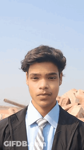 Young Man In Blue Shirt And Tie With TMC Bricks GIF