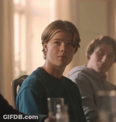 Young Man In Blue Shirt At Table GIF