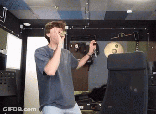 Young Man In Blue Shirt Covering Face Holding Microphone GIF