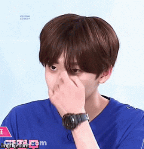 Young Man In Blue Shirt Covering Face With Watch GIF
