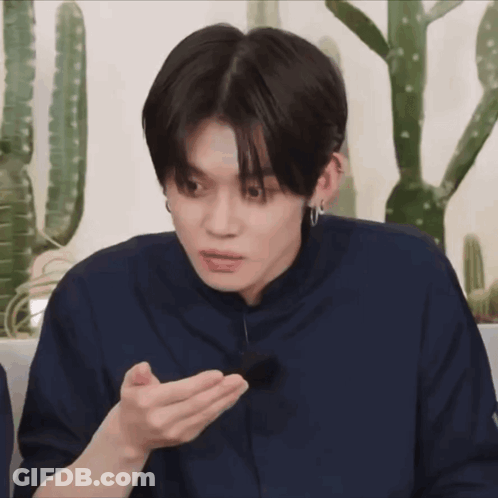 Young Man In Blue Shirt Holding Something Near Cactus GIF