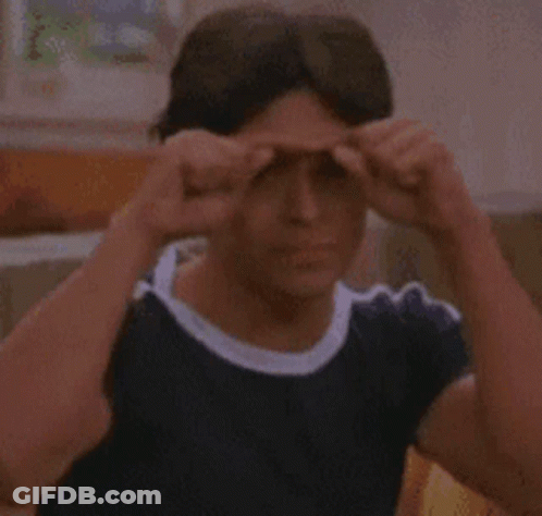Young Man In Blue Shirt Making Funny Face On Couch GIF