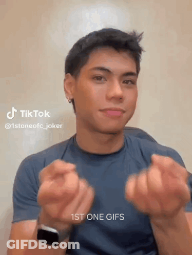 Young Man In Blue Shirt Making Heart Shape With Watch GIF