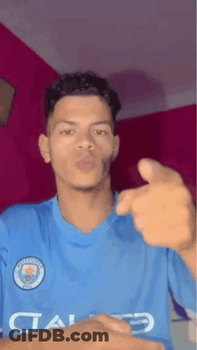 Young Man In Blue Shirt Pointing And Blowing Kiss GIF