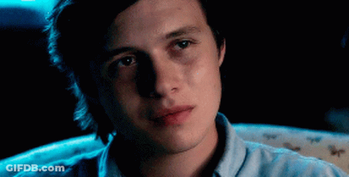 Young Man In Blue Shirt Sitting In Darkness GIF
