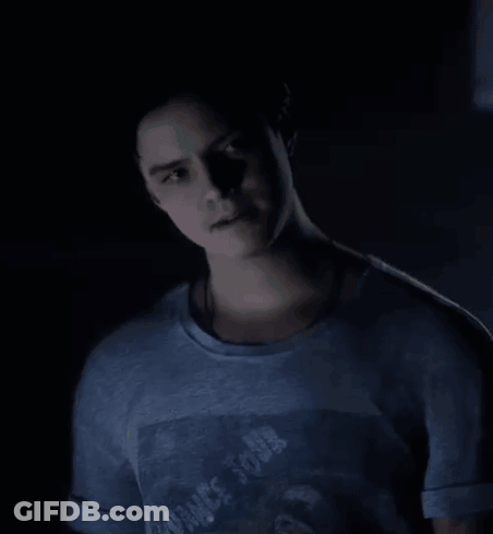 Young Man In Blue T-Shirt With Man Picture Standing In Dark Room GIF