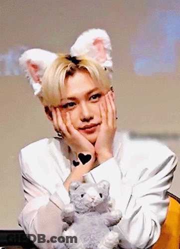 Young Man In Bunny Ears Holding Stuffed Animal GIF