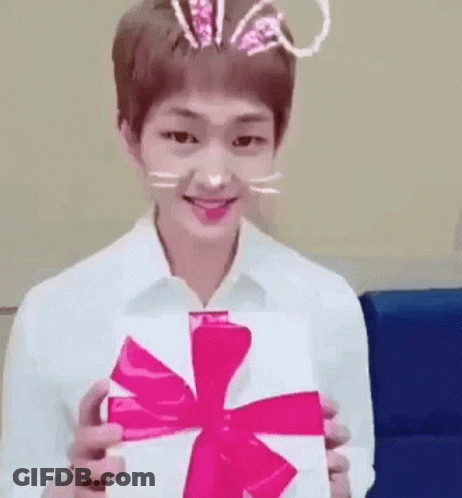 Young Man In Bunny Ears Holding White Box With Pink Bow GIF
