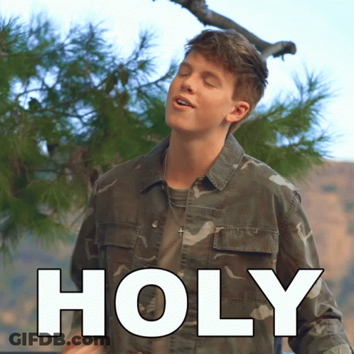 Young Man In Camouflage Jacket Standing Before Holy Sign GIF