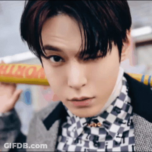 Young Man In Checkered Shirt Holding Yellow Sign GIF
