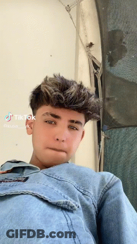 Young Man In Denim Jacket Looking At Camera GIF