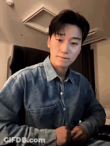 Young Man In Denim Shirt Sitting GIF