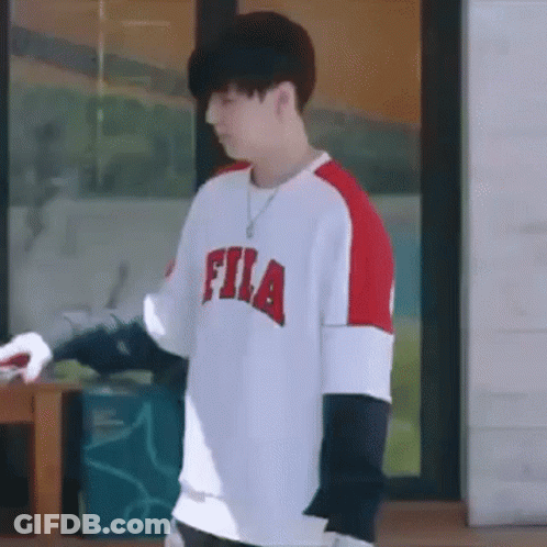 Young Man In Fila Shirt Standing In Front Of Window GIF