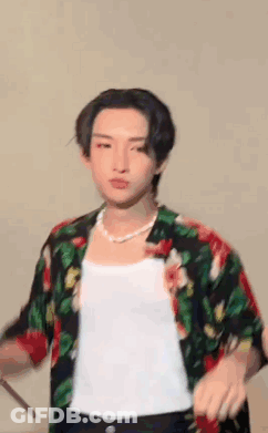 Young Man In Floral Shirt Holding Drum Stick GIF