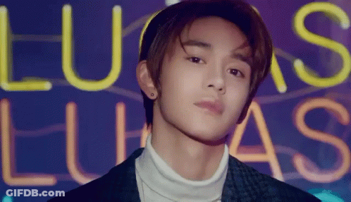 Young Man In Front Of Lucas Neon Sign GIF