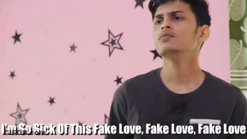 Young Man In Front Of Pink Wall Says I'm So Sick Of This Fake Love GIF