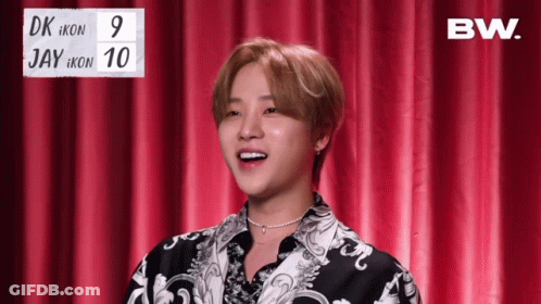 Young Man In Front Of Red Curtain With BW Sign GIF